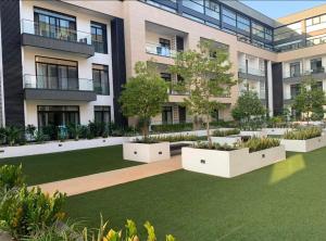 un immeuble d'appartements avec un jardin en face dans l'établissement Embassy Gardens Apartments, à Cantonments