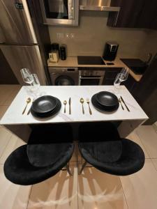 stół w kuchni z czarnymi płytami i okularami w obiekcie Embassy Gardens Apartments w mieście Cantonments