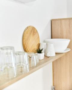 a wooden shelf with glasses and a bowl on it at Kuća Nerezinka in Nerezine