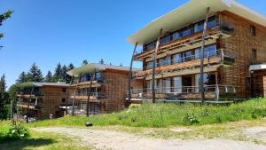 a large brick building with balconies on a dirt road at Charmant appartement au pied des pistes in Chamrousse