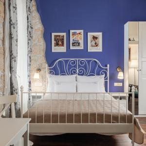 a blue bedroom with a bed with a blue wall at Photel Apartments in Crikvenica