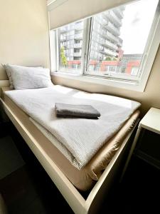 a bed in a room with a window at Home in Downtown in Toronto