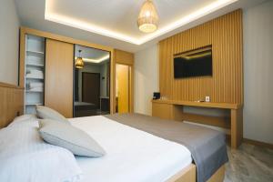 a bedroom with a white bed and a television at Maye Residence in Gümbet