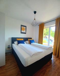 two beds in a bedroom with a large window at Ferienwohnung Lucia in Schiefling am See