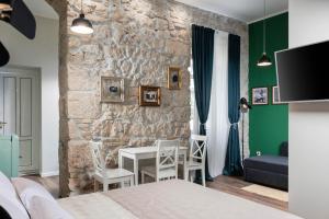 a bedroom with a stone wall and a table and chairs at Photel Apartments in Crikvenica