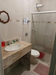 a bathroom with a sink and a toilet and a shower at Pousada Kundalini Arraial in Arraial do Cabo