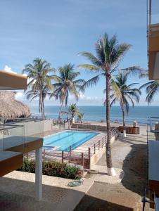 uma vista para a praia a partir da varanda de um resort em NAHIR apartamento de playa en condominio Palmar del viento em San Bernardo del Viento