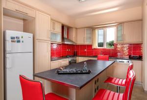 a kitchen with a black counter top and red appliances at Valia's House in Kato Daratso