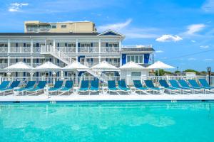 um hotel com cadeiras e uma piscina em Mahalo Cape May Townhomes em Cape May