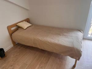 Łóżko w sypialni z drewnianą podłogą w obiekcie Studio cité gastronomique w mieście Dijon