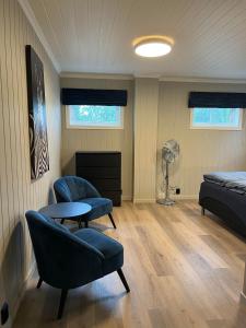 um quarto com duas cadeiras, uma cama e uma mesa em Gårdsopphold Notodden em Notodden