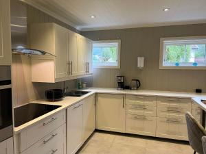 a kitchen with white cabinets and white counters at Gårdsopphold Notodden in Notodden