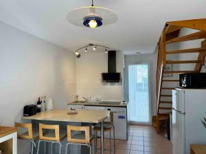 een keuken met een tafel en stoelen in een kamer bij Charmante maison à nbne plage in Narbonne