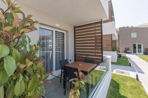 a balcony with a wooden table and chairs at Val Del Mar in Skala Fourkas