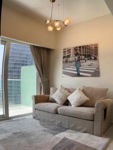 Athesa Apartments Downtown Dubai Business Bay في دبي: غرفة معيشة مع أريكة ونافذة كبيرة