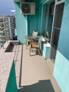 a balcony with a table and a television on a building at Apartament Summerland Crazy Beach Mamaia in Mamaia