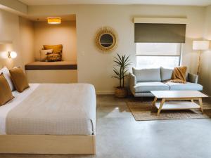 Brut Hotel في تولسا: غرفة نوم بسرير واريكة
