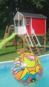 a playground with a house and a ball in front of a pool at Apartamenty Sadowy in Wisła