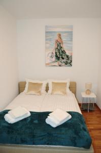 ein Schlafzimmer mit einem Bett mit zwei Handtüchern darauf in der Unterkunft Artus Apartment in Danzig