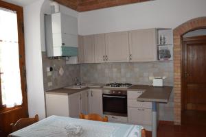 a kitchen with white cabinets and a table with a table sidx sidx sidx at Appartamento Polino in Chianciano Terme