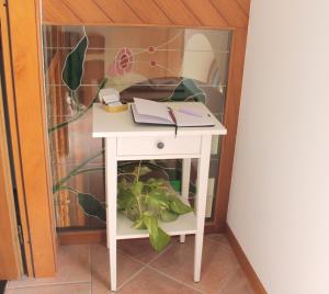 een klein wit bureau met een boek erop bij Ai Cantarelli in Lugagnano