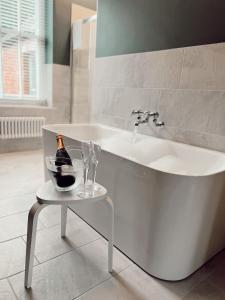 a bathroom with a tub and a bottle of champagne on a table at Riversdale House Bed & Breakfast in Llangollen
