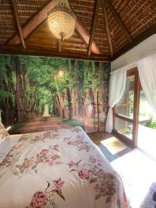 a bedroom with a wall mural of a forest at Cabana Do Zuza in Campos do Jordão
