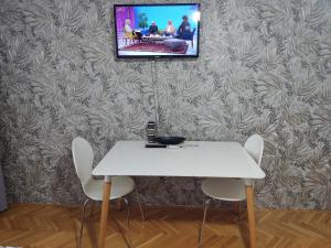 ブルチコにあるStan na dan Brcko MBRadic zgradaの白いテーブルと椅子(壁にテレビ付)