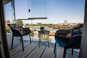 a balcony with two chairs and a table and a window at Sodoben apartma v centru Ljubljane in Ljubljana