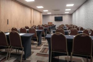 uma sala de conferências com mesas e cadeiras e um ecrã em Like Design Hotel Rivera em Rivera