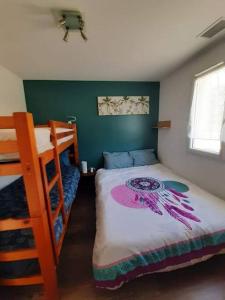 ein Schlafzimmer mit einem Bett und einem Etagenbett in der Unterkunft CAP MONTA - Maison Neuve in Vendays-Montalivet
