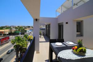 a balcony with a table and a view of a street at Heraklion Harbour Penthouse in Heraklio Town