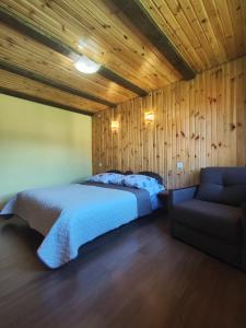 ein Schlafzimmer mit einem Bett und einem Sofa in der Unterkunft Карпатський куточок in Slawske