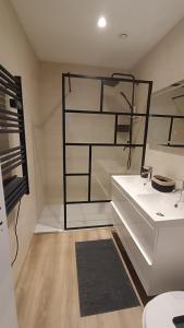 W łazience znajduje się biała umywalka i czarna półka. w obiekcie Duplex - Palais de Justice w Tuluzie