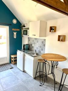 uma cozinha com uma mesa de madeira e uma mesa em Studio avec grand jardin + parking em Seraincourt