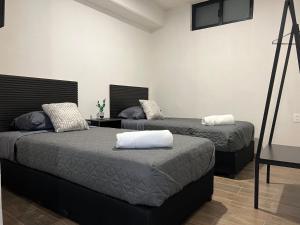 a bedroom with two beds and a tv on the wall at #1 Edificio Tía Flora in León