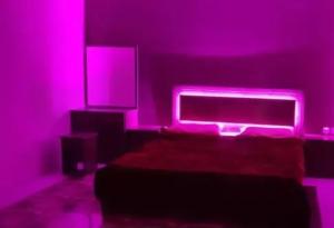 ein Schlafzimmer mit einem Bett mit rosa Lichtern in der Unterkunft شاليه حنونة الطائف in Ta'if