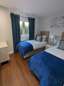 a bedroom with two beds and a window at Kinetic Stays - Serenity Holiday Cottages in Sidmouth