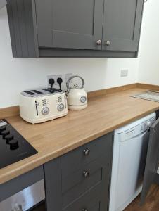 a kitchen counter with a toaster on top of it at Myrtle Stables - converted, self-contained, countryside in Hernehill +19 photos