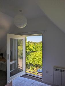 a bedroom with a large window with a view at Myrtle Stables - converted, self-contained, countryside in Hernhill