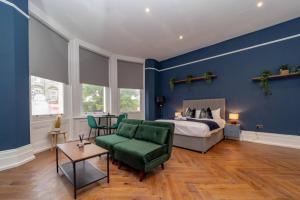 - une chambre bleue avec un lit et une chaise verte dans l'établissement King Size Bed I Central Location I Smart TV, à Brighton et Hove