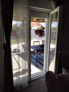 a sliding glass door leading to a patio with a table at Country house Angela in Košute