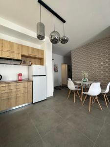 a kitchen with a table and a white refrigerator at Apartment Caroline in Sarandë