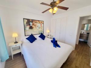 Un dormitorio con una gran cama blanca con almohadas azules. en Flower Beach 14, en San Bartolomé