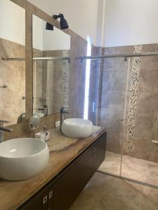 bagno con lavandino e doccia in vetro di Girardot Casa estilo mediterraneo con piscina privada a Girardot