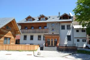 uma grande casa branca com um telhado em APARTMA VODNIK em Bohinj