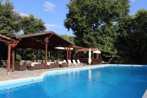 a large swimming pool with chairs and a pavilion at Kotza Ntere in Axioúpolis