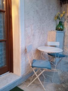 einen Tisch, zwei Stühle, einen Tisch und eine Vase in der Unterkunft Casa Elisa apartment in Armeno