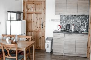 a kitchen with a wooden table and a refrigerator at Rezidencia Podhájska in Podhájska