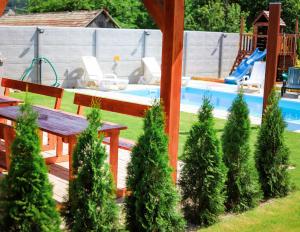 a backyard with a wooden bench and a pool at Rezidencia Podhájska in Podhájska